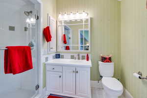 Full bath featuring a shower stall, toilet, vanity, and tile patterned flooring