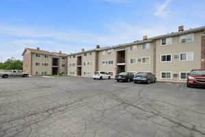 View of building exterior featuring uncovered parking