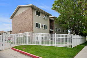 View of property exterior with brick siding and an AC wall unit