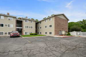 View of property featuring uncovered parking and fence