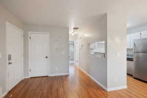Hallway featuring light wood-style flooring and baseboards