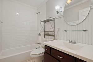 Bathroom with ornamental molding, toilet, shower / bathtub combination, and vanity