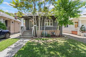 View of front of home with covered porch and a front lawn