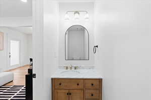 Powder Bathroom with vanity and wood finished floors off living room