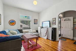 Living area with arched walkways and wood finished floors