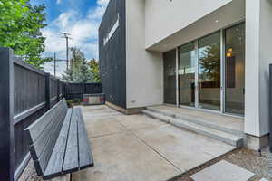Back patio with builtin bench and fenced backyard.