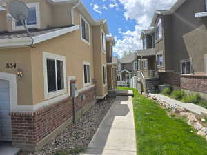 View of property exterior with brick siding, stucco siding, and a residential view