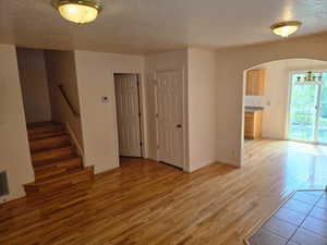 Family Room room with wood flooring, a textured ceiling, a chandelier, and stairway