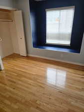 Unfurnished bedroom with wood finished floors and baseboards