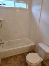 Full bath with toilet, bathtub / shower combination, and tile patterned floors
