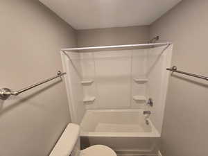 Basement Bathroom with toilet and tub / shower combination