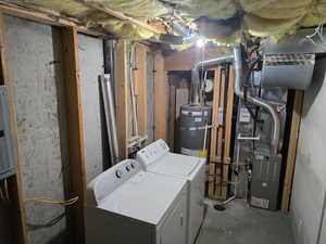 Unfinished basement area featuring washer and clothes dryer and water heater