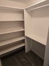Walk in closet featuring dark carpet
