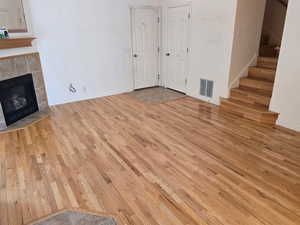 Family Room featuring wood finished floors, stairs, a tile fireplace, and baseboards