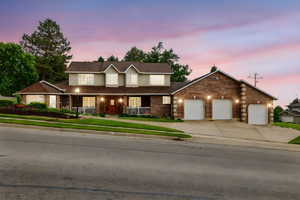 View of front facade featuring a porch, concrete driveway, an attached garage, and brick siding