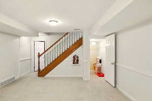 Staircase featuring under stairway play area, carpet flooring and baseboards