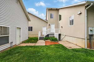 Rear view of property featuring entrance to basement ADU and workshop