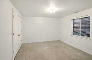 ADU bedroom featuring baseboards, light colored carpet, and a closet