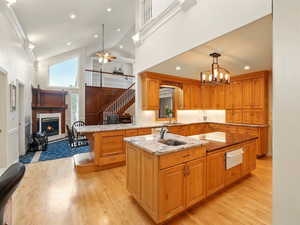 Kitchen with a warming drawer, light wood flooring, and high vaulted ceiling