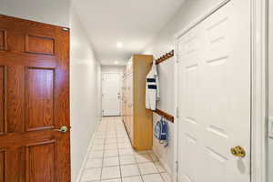 Mudroom with exterior and garage access, featuring light tile patterned floors, baseboards, and recessed lighting