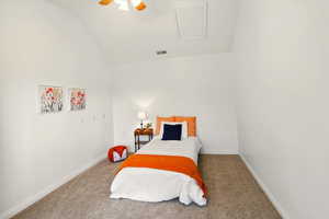Carpeted bedroom with lofted ceiling, baseboards, and ceiling fan