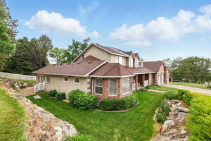 View of property exterior featuring stucco siding, concrete driveway, terraces lawn, and a shingled roof
