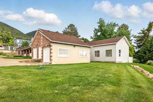 Side view of house with a yard, a garage, driveway, and a mountain view