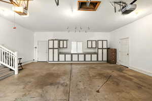 Garage featuring a garage door opener and cabinets