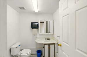 Workshop 1/2 bathroom featuring a sink and toilet, plumbed for shower
