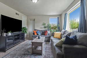 Living room featuring a textured ceiling and carpet flooring