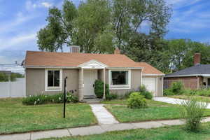 View of front of home featuring stucco siding, concrete driveway, a chimney, and central AC