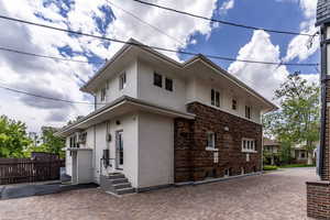 View of property exterior featuring stucco siding, fence, and entry steps