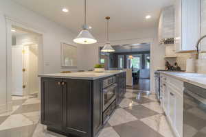 Kitchen with appliances with stainless steel finishes, white cabinets, backsplash, recessed lighting, and a sink