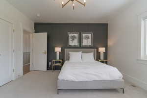 Carpeted bedroom featuring a chandelier