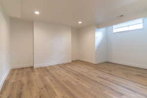 Unfurnished room with light wood finished floors, recessed lighting, and baseboards