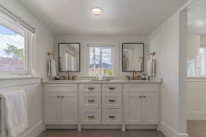 Bathroom with baseboards, double vanity, recessed lighting, and tile patterned flooring