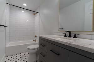 Bathroom featuring toilet, vanity, bathtub / shower combination, recessed lighting, and tile patterned floors