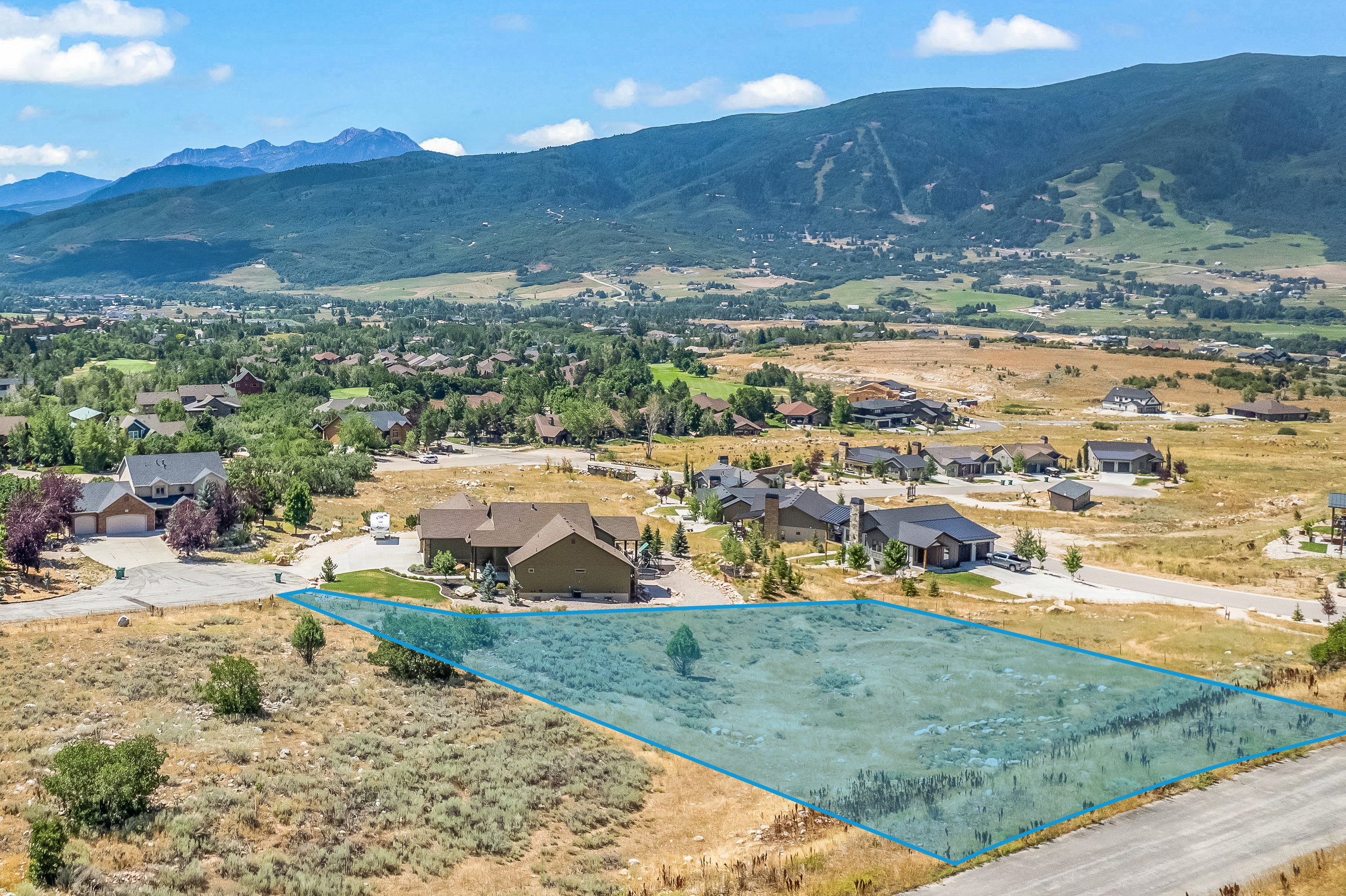 Aerial perspective of suburban area featuring a mountain backdrop and property boundaries highlighted