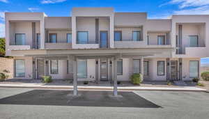 View of property featuring covered parking and stucco siding