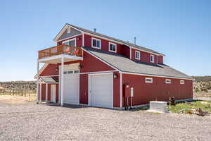View of front of property featuring a balcony and a shingled roof