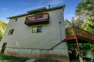 View of side of property featuring a balcony and a deck