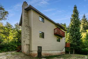 View of property exterior with a balcony and a chimney