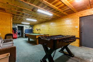 Playroom with carpet flooring, wood walls, billiards table, and wooden ceiling