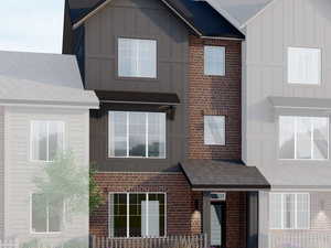 View of front of house featuring board and batten siding and brick siding