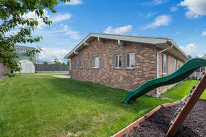 View of home's exterior with a shed, brick siding, and an outbuilding