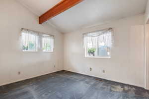 Unfurnished room featuring dark carpet and baseboards