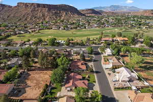 View of property location featuring nearby suburban area, a mountain backdrop, and a golf course