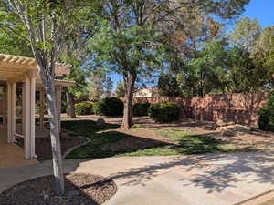 View of yard featuring a pergola, a patio area, and fence