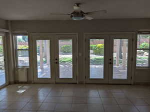 Doorway featuring french doors, plenty of natural light, and light tile patterned floors
