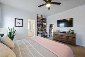 Bedroom with carpet, ensuite bathroom, ceiling fan, and baseboards